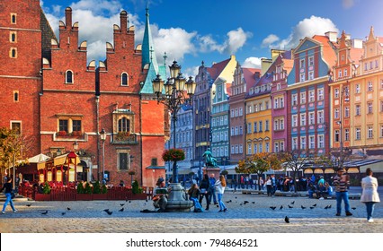 Wroclaw Central Market Square With Old Colourful Houses, Street Lamp And Walking Tourists People At Evening Sunset Sunshine.