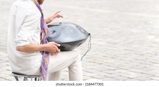 Wroclaw, Poland - April 2022: Man Playing The Hang Drum, Handpan, Steelpan Outdoors, Hands Closeup Detail, Slow Motion Shot. Music, Unusual Percussion Instruments, Relaxation Concept, One Person