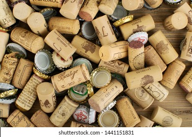 Wroclaw, Poland - April 22, 2019: randomly scattered used wine corks background mixed with metal caps from different beer bottles top view