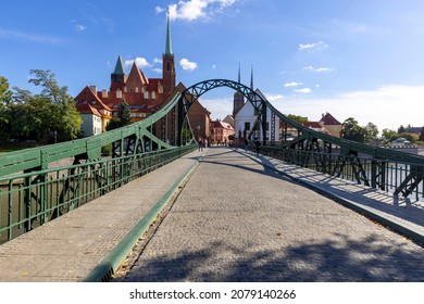 Wroclaw, Poland - September 30, 2021: View of the Tumski Bridge, towers of Collegiate Church of the Holy Cross and St Bartholomew and Wroclaw Cathedral on Ostrow Tumski