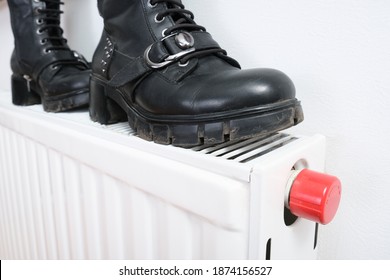 Wrong Drying Of Footwear, A Pair Of Dirty Leather Winter Shoes On A Hot Central Heating Radiator.