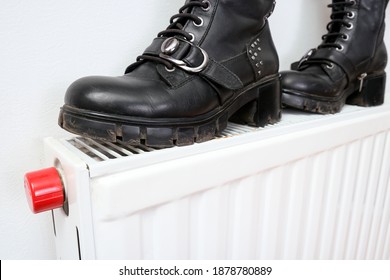 Wrong Drying Of Footwear, A Pair Of Dirty Leather Winter Shoes On A Hot Central Heating Radiator.