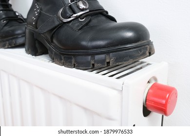 Wrong Drying Of Footwear, A Pair Of Dirty Leather Winter Shoes On A Hot Central Heating Radiator.