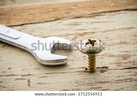 Wrong tool for this job. Screw and open end wrench on old wooden background. Recruitment, HR human resources management in business company, put the right man on the right job concept.