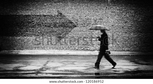 Wrong way. A man with umbrella. Conceptual image,\
film grain added