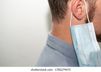 Wrong way to wear coronavirus mask on his ear - Powered by Shutterstock