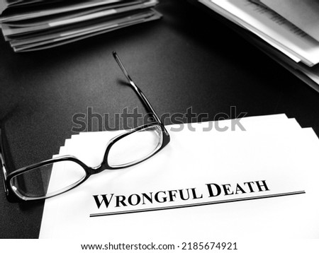 Wrongful death papers on desk with glasses for legal services or lawsuit