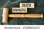 WRONGFUL DEATH - words on wooden blocks on a green background with a judge