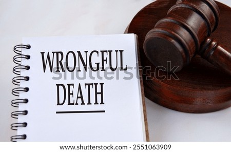 WRONGFUL DEATH - words in a white notebook with a judge's gavel in the background