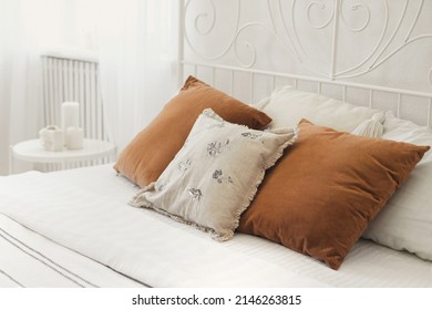 Wrought iron bed with pillows on the bed in cozy bedroom from natural ecological materials linen and velvet. Details of trendy and eco-friendly living room in light beige and brown earth colors.  - Powered by Shutterstock