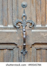 Wrought iron door pull handle decorating an antique front entry