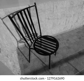 Wrought Iron Garden Chair Creating Shadows Upon Shadows On Patio Tiles.