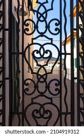 Wrought iron gate in front of a typical Italian courtyard in the island capital Portoferraio on the island of Elba in Italy under a bright blue summer sky