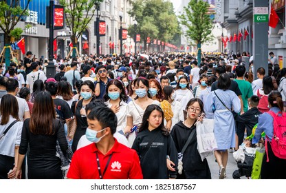 Wuhan China , 1 October 2020 : Crowd of people wearing surgical face mask on the 2020 China national day and first day of golden week holidays in Jianghan pedestrian road in Wuhan Hubei China