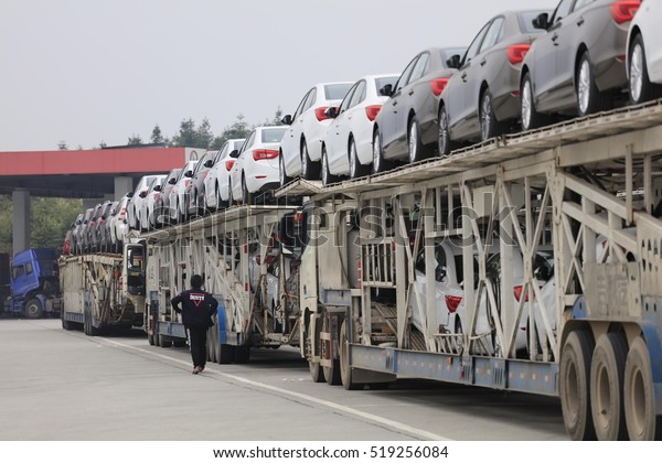 Wuhan China -2016 April 2: the highway service\
area, dozens of trucks loaded with new car stops, like long\
pendulum. China\'s auto production and marketing rapid growth,\
ranking first in the\
world.\
