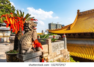 Wuhu Anhui Guangji Buddhist Monastery Temple Lion Sculpture With Hall Of Four Heavenly Kings Roof View On A Sunny Blue Sky Day