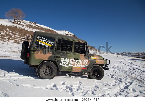 WULAN BUTONG, CHINA, DECEMBER 31, 2017:\
camouflage jeep car on snow\
mountain