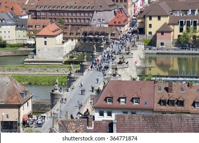 Wurzburg, Germany - May 4, 2014: People cross the old Main Bridge across the Main river seen from above in Wurzburg, Germany on May 4, 2014