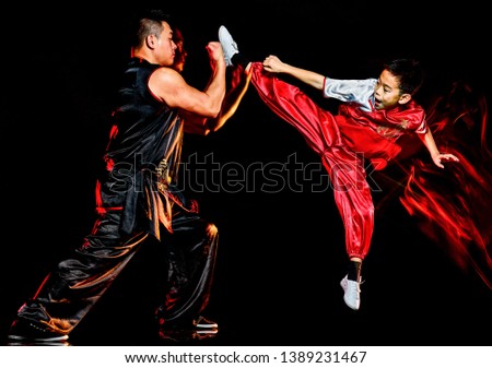 wushu chinese boxing kung fu Hung Gar fighter isolated child and man isolated on black background with speed light painting effect motion blur
