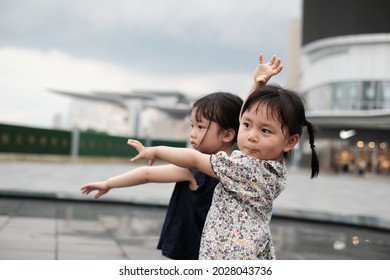 Wuxi, China - May 15 2021: Two Little Asian Kids Dancing And Having Fun In A Cloudy Day When The Storm About To Come In An Open Square Before A Mall In Wuxi, Southeast China. Happy Childhood. 