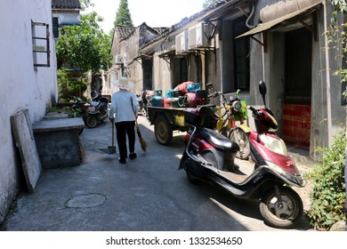 Wuzhen, China - June 8 2017: A Street Cleaner Sweeping An Alley In The Old Town Of Wuzhen