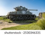 WWII Sherman tank at Normandy, France, standing as a historic reminder of the D-Day invasion. Rusted yet powerful, this tank commemorates the bravery of Allied forces.