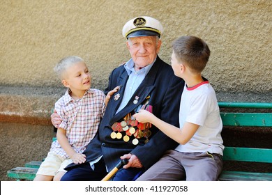 WWII Veteran With Children. Grandchildren Looking At Grandfather's Military Awards.