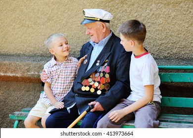 WWII Veteran With Children. Grandchildren Looking At Grandfather's Military Awards.