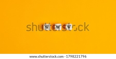 WWW inscription on wooden blocks against yellow background. Flat lay view. 