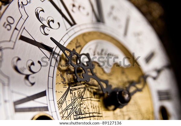 The X hour An old-style pendulum\
clock face with focus on the hour hand pointing to X or\
10
