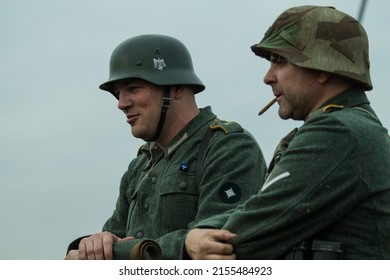 X INTERNATIONAL FESTIVAL GIVE KIEV , 03.11.13, Kiev, Ukraine. Two Fascist German Soldiers In Nazi Uniforms And Helmets Communicate And Smoke Cigarettes