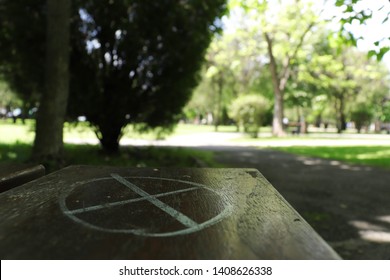 X Marks The Spot On A Bench In A Park