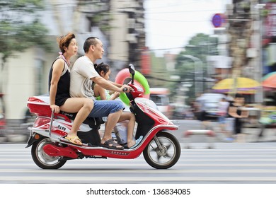 XIANG YANG-CHINA-JULY 3. Chinese Couple With Their Child On A Scooter. Chinas Family Planning Policy Officially Restricts Married, Urban Couples To Having Only One Child. July 3, 2012, Xiang Yang