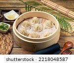 Xiao Long Tang Bao with wood spoon and napkin served in a wooden dish side view of taiwan food