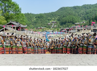 Xijiang, China - SEPTEMBER 2,2020: Miao women dancing in full traditional festival regalia and colorful costume with silver horn headdress in Xijiang ethnic minority Miao village, Guizhou, China