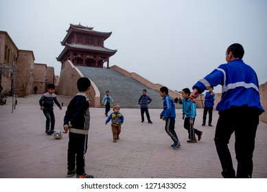 Xinjiang,China,January 1 2019- A Group Of Uyghur Children Playing Football In Front Of Abandon Temple In The Old City Of Kashgar. Kashgar Has Majority Of A Muslim Uyghur Ethnic In China.