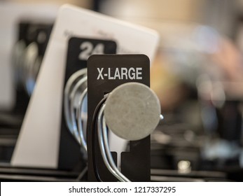 X-large End Cap Sign On Steel Clothes Hanging Rack With Hangers In A Department Store