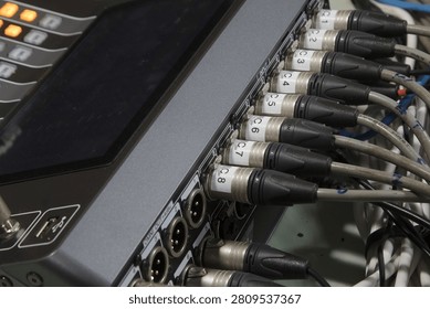 XLR microphone cables on the back of the digital mixer.