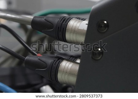 XLR microphone cables on the back of the digital mixer.