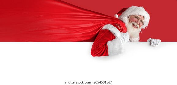 Xmas Santa Claus on whiteboard, holding sack on red background. Emotional senior male model old man with a natural white beard Father Christmas. Joyful character for advertising - Powered by Shutterstock