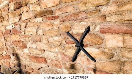 X-shaped Iron Anchor Plate On A Stone Building In The Afternoon Sun