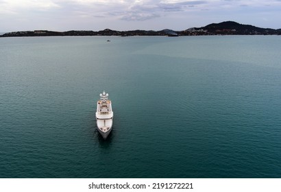 Yacht Anchored Off Shore Of Banrak Bay At Ko Samui Island In Thailand - Drone Aerial Frontal Shot With Open Water All Around The Yacht