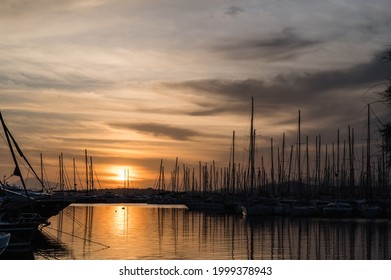 Yacht and boats parking in harbor. White sailing yachts at the pier. Sea yacht club. Aegean sea. Athens, Greece. Sunset sky.