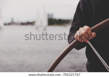Yacht captain hand on yacht steering wheel