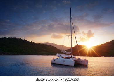 Yacht - Catamaran in the tropical sea at sunset. Yachting / Luxury Sailing theme.