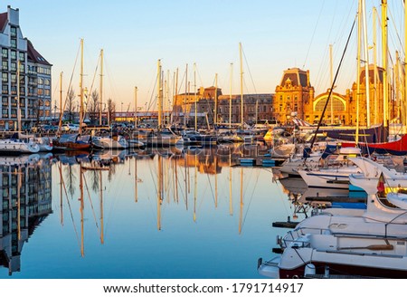The yacht harbor of Oostende (Ostend) with train station at sunset, Belgium.