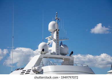 Yacht Navigation Equipment Concept. Luxury Rooftop, Satellite Radar, Antenna, Technical Support, Wireless Transmission, Safe Shipping, Under Greek Blue Sky And Flag Background, Marina Flisvou, Greece.