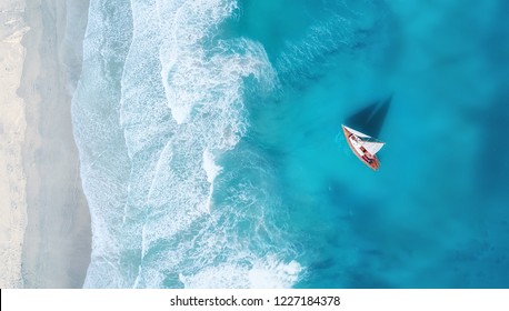Yacht on the water surface from top view. Turquoise water background from top view. Summer seascape from air. Travel concept and idea - Shutterstock ID 1227184378