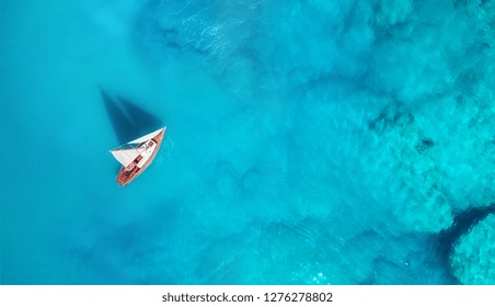 Yacht on the water surface from top view. Turquoise water background from top view. Summer seascape from air. Travel concept and idea - Powered by Shutterstock