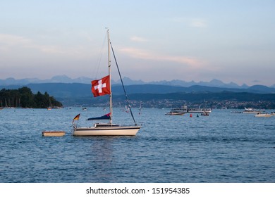 Yacht Sailing Across Lake Zurich In Sunset